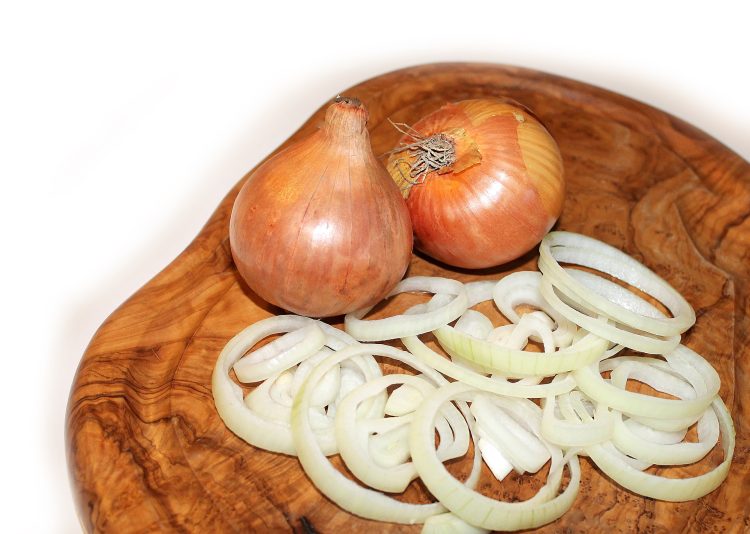 Sliced onions on wooden board